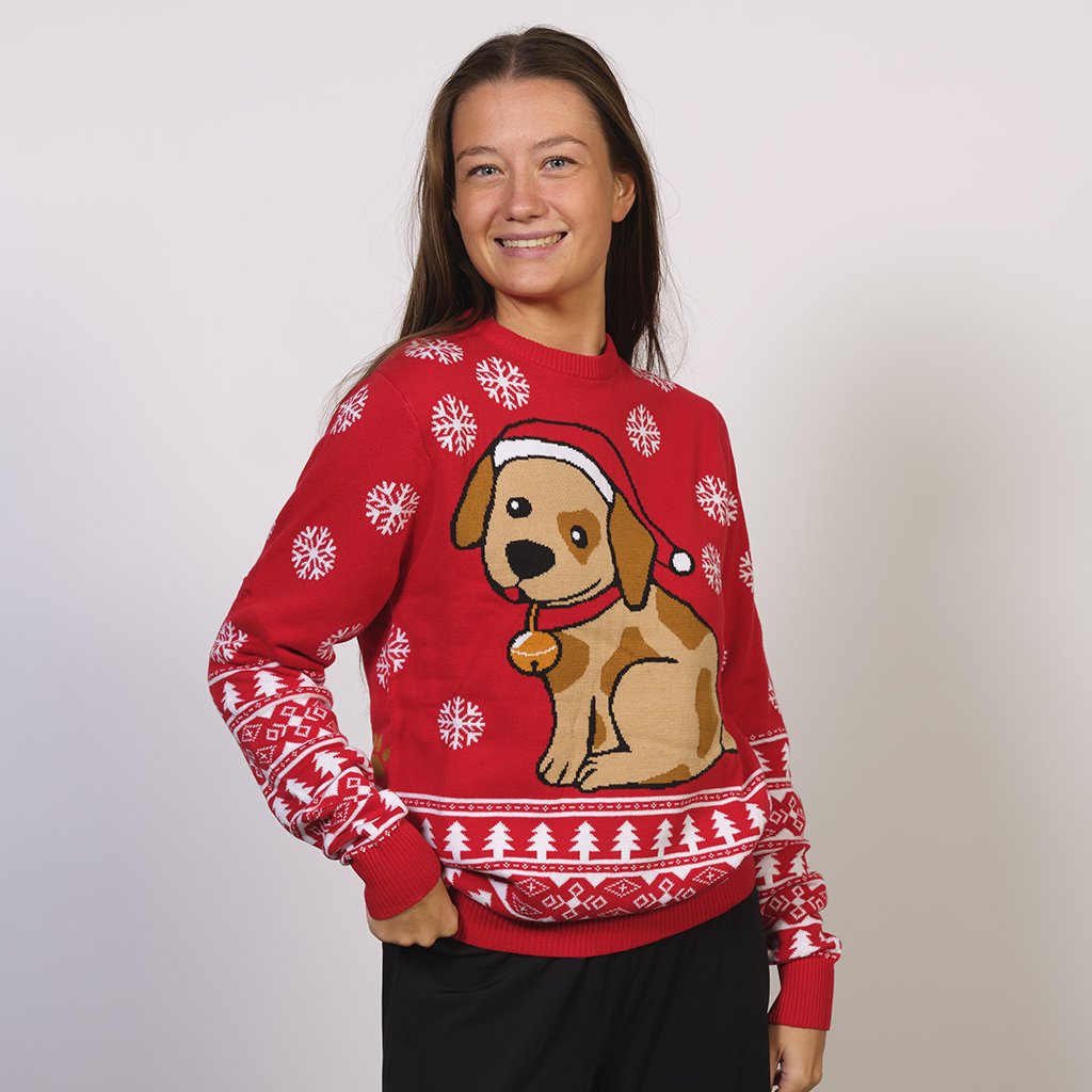 Une femme portant un pull de Noël rouge avec un chien et des flocons de neige.